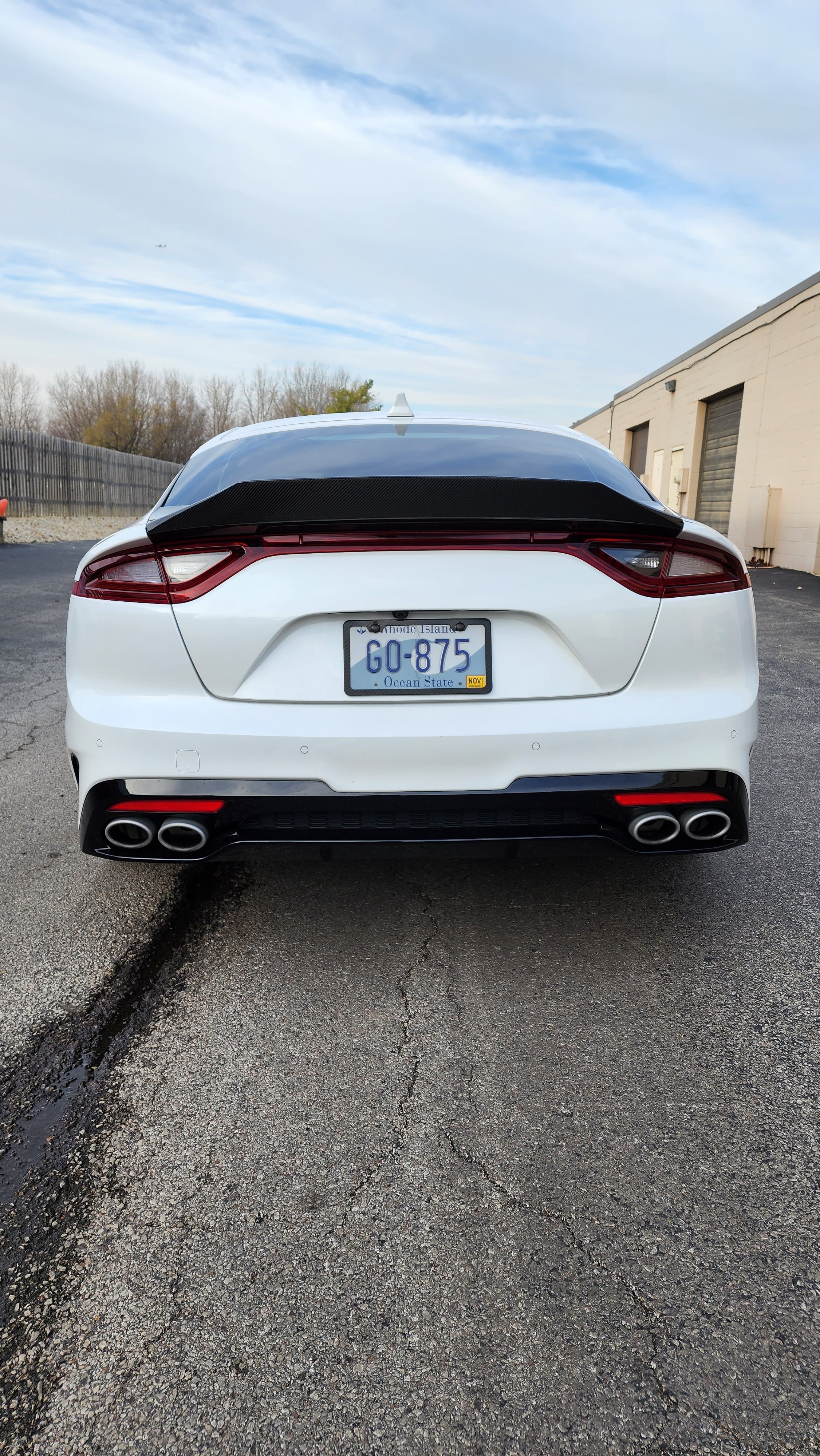 Rear angle perspective of the Kia Stinger with Jalisco's Carbon Half Trunk Spoiler, focusing on the spoiler's impact on the vehicle's rear aesthetic and its aerodynamic design