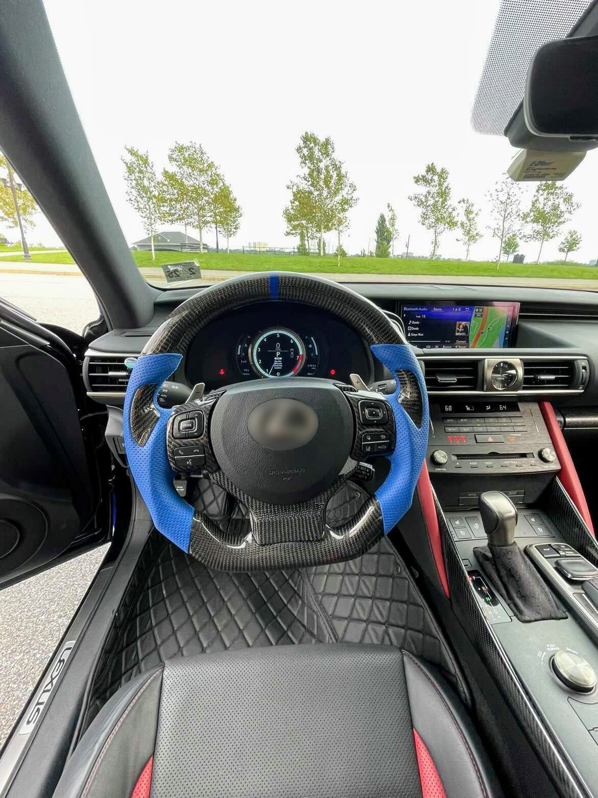 Car interior with a custom carbon fiber steering wheel and dashboard view
