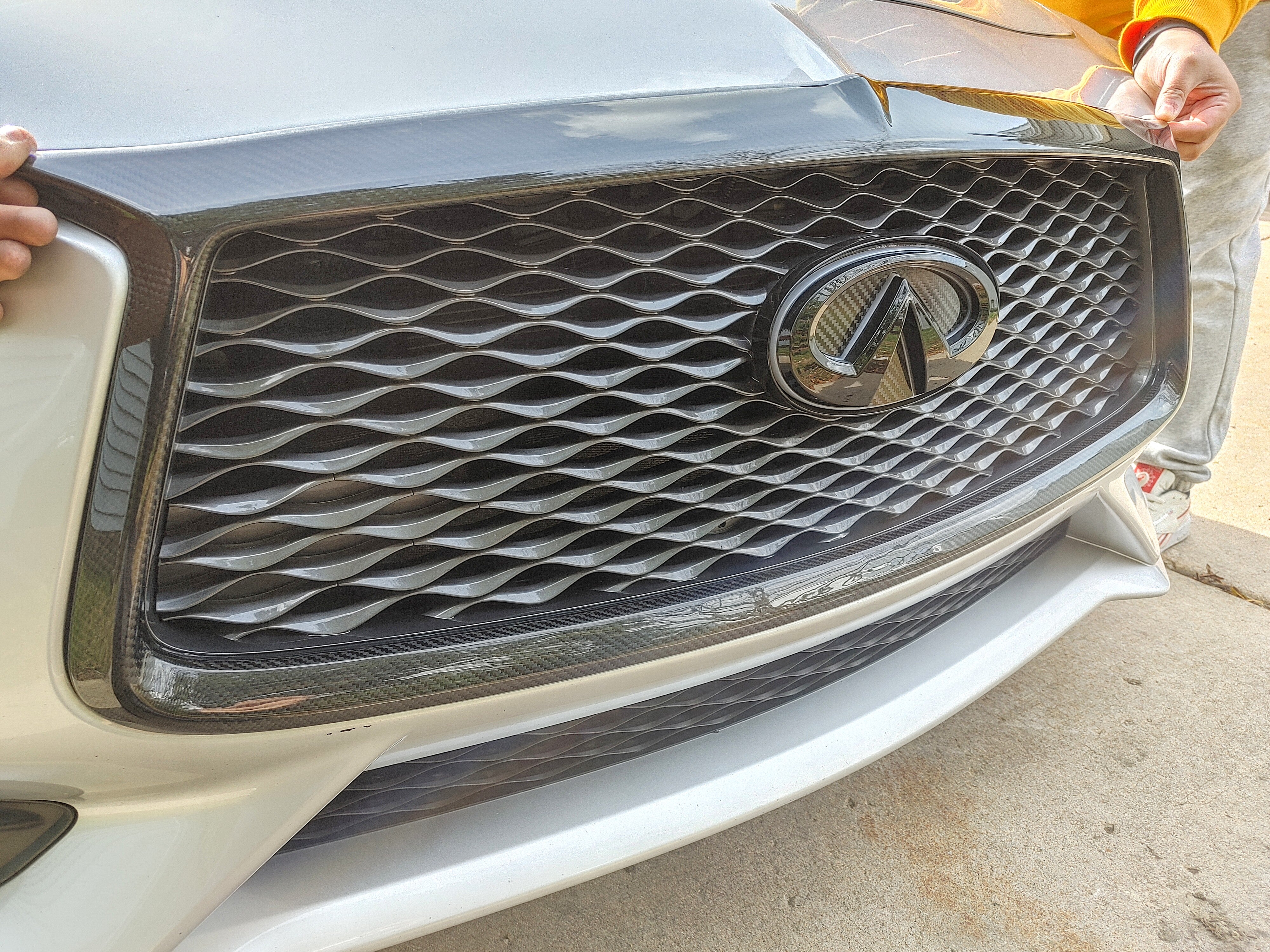 Close-up of the Carbon Fiber Grill Trim Overlay by Jalisco, showcasing the precise fitment and ready for easy double-sided tape application.