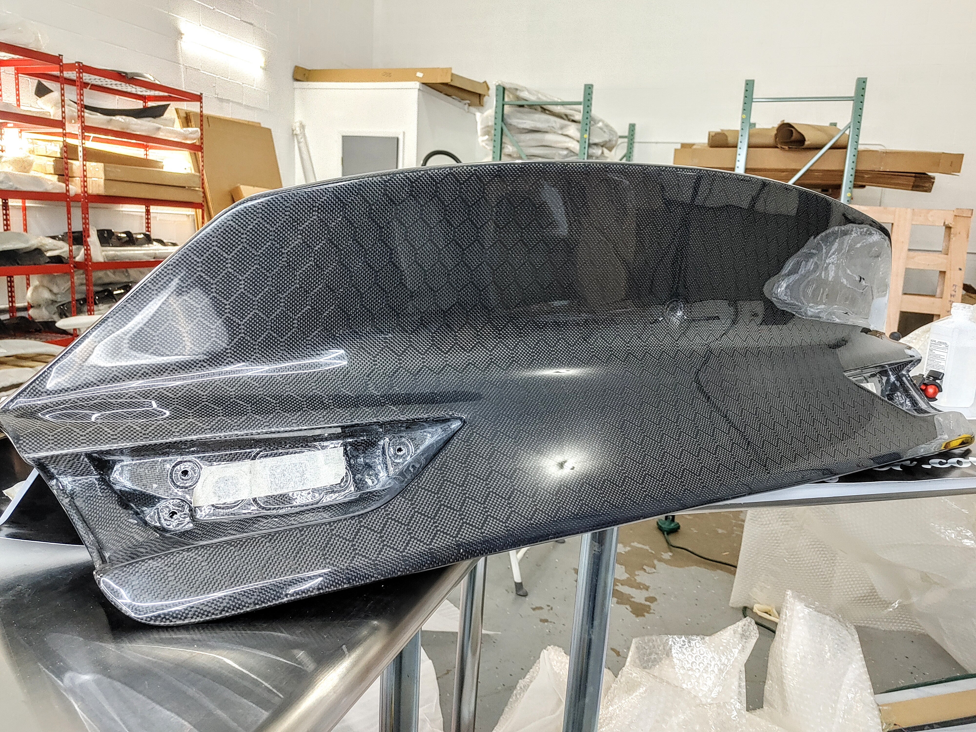 Jalisco's Q60 Duckbill Trunk in pre-installation phase, highlighting its sleek carbon fiber texture