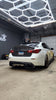 Load image into Gallery viewer, JCF Carbon Fiber Trunk on a white Infiniti Q50 seen from a low angle in a garage, highlighting the trunk&#39;s sporty aesthetic and the car&#39;s enhanced rear profile.