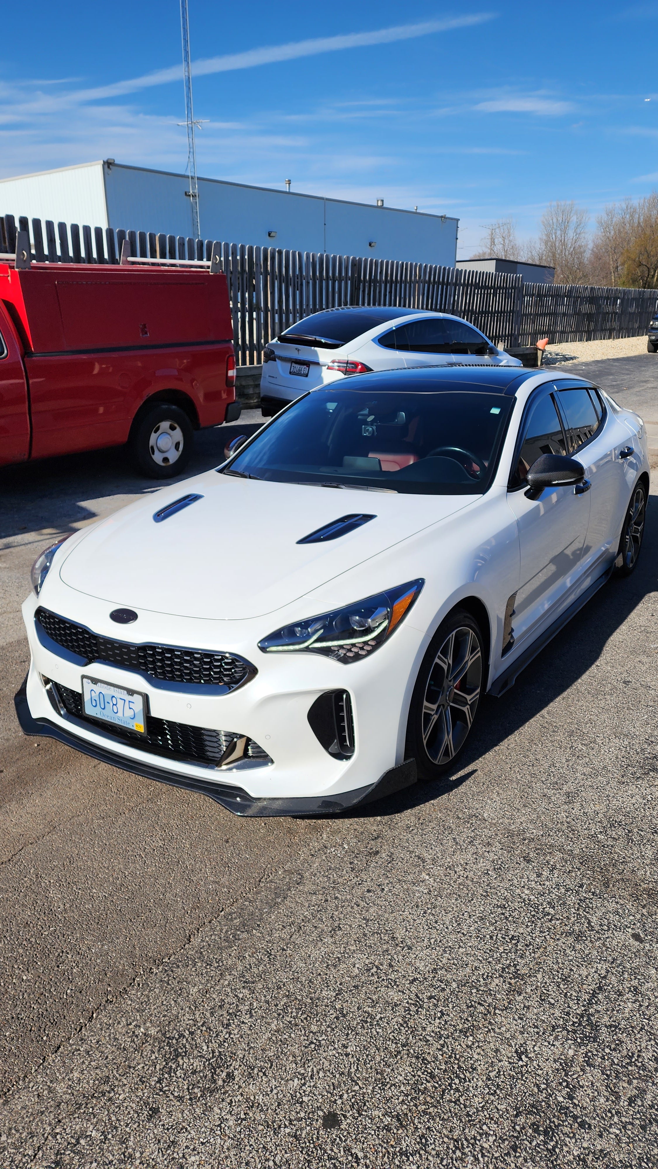 Slightly angled front view of the Kia Stinger with the Jalisco CarbonFiber Front Lip, showcasing the lip's enhancement of the car's aggressive stance