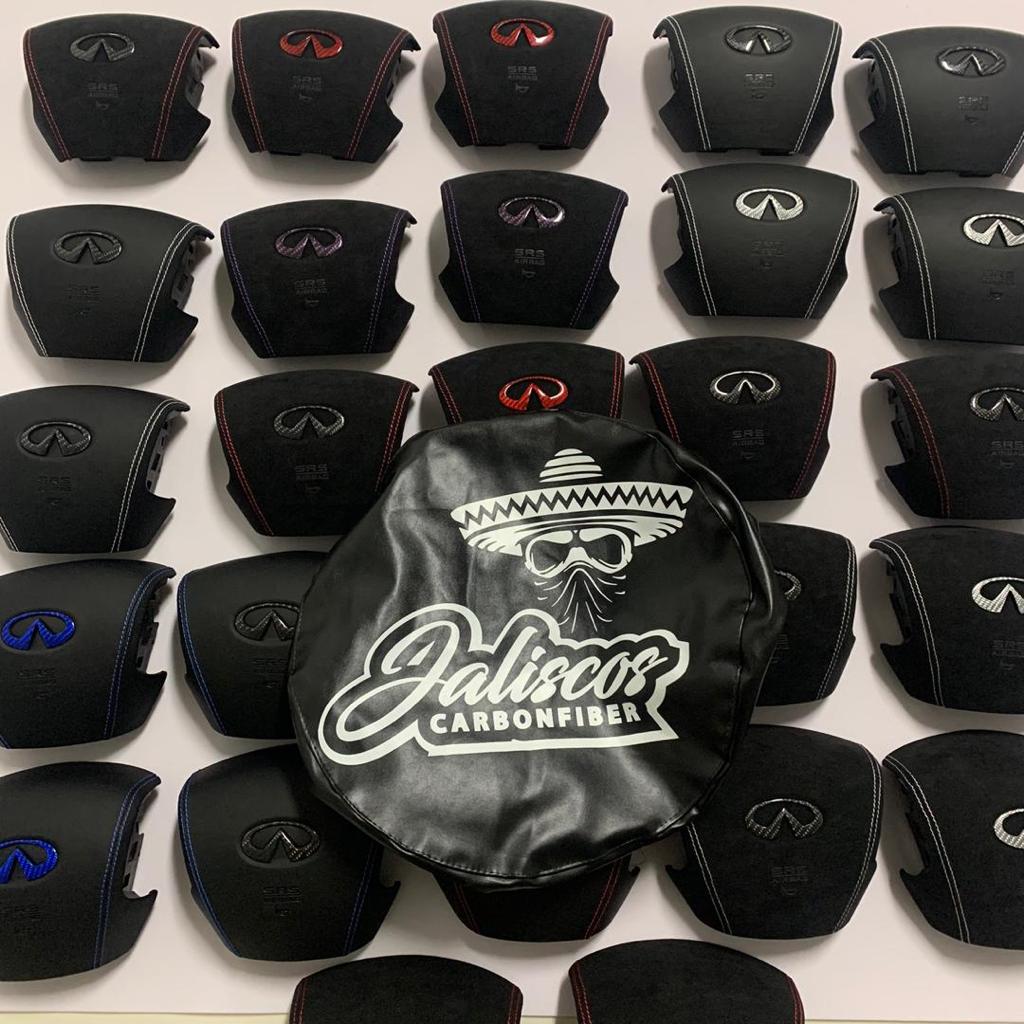 Collection of Jalisco's CarbonFiber Custom Airbag Covers for Infiniti Q50 2014-2017 in an array of colors, each accentuated with distinctive stitching, all centered around a prominently displayed cover featuring a carbon fiber Infiniti emblem.