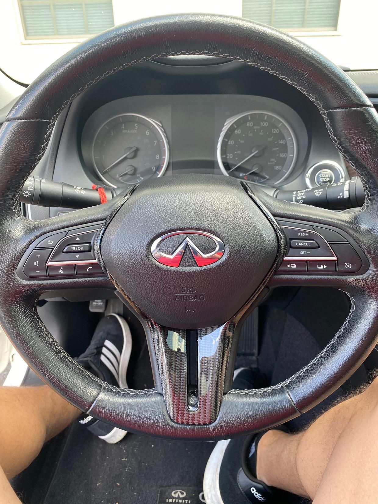 Jalisco's carbon fiber trim for the Infiniti Q50 steering wheel: a high-gloss, intricately woven carbon pattern enhancing the wheel's aesthetics, reflecting premium craftsmanship and elegance.