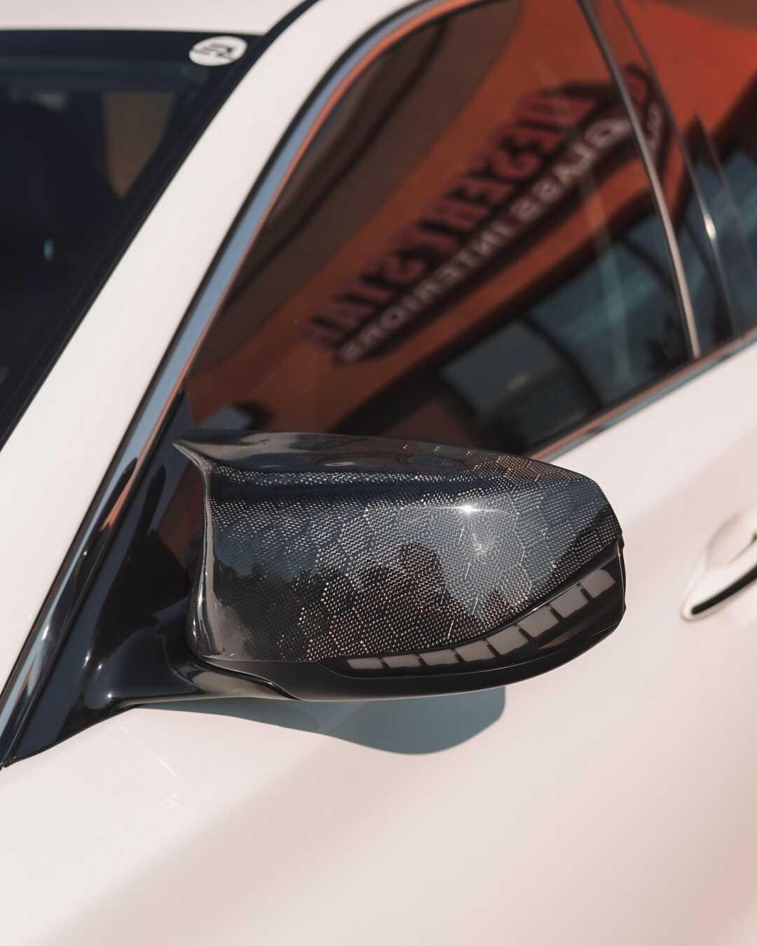 Close-up of the real carbon fiber weave on Jalisco's V1 M-Style Replacement Mirror Caps, highlighting the exquisite detailing.