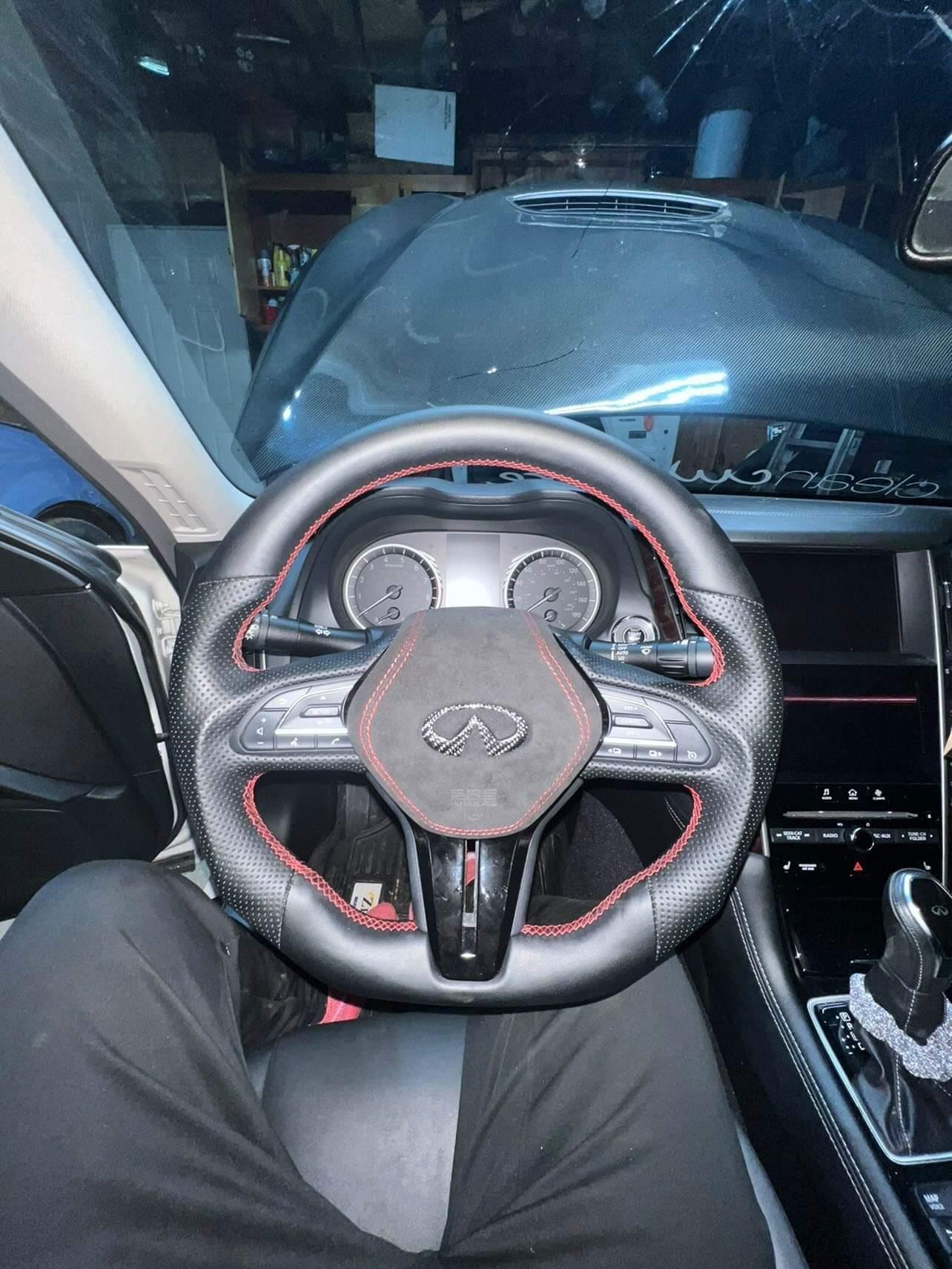 Jalisco's custom cover for the Infiniti Q50/Q60 steering wheel airbag: sleek black design accented with meticulous red stitching, emphasizing the precision and elegance of the customization