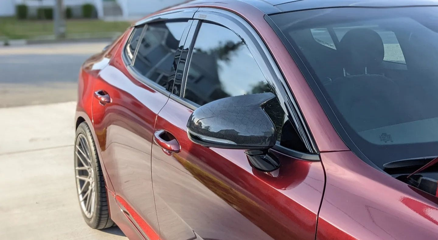 Side angle of Kia Stinger with Jalisco CF M-Style Mirror Cap, reflecting sleek design.