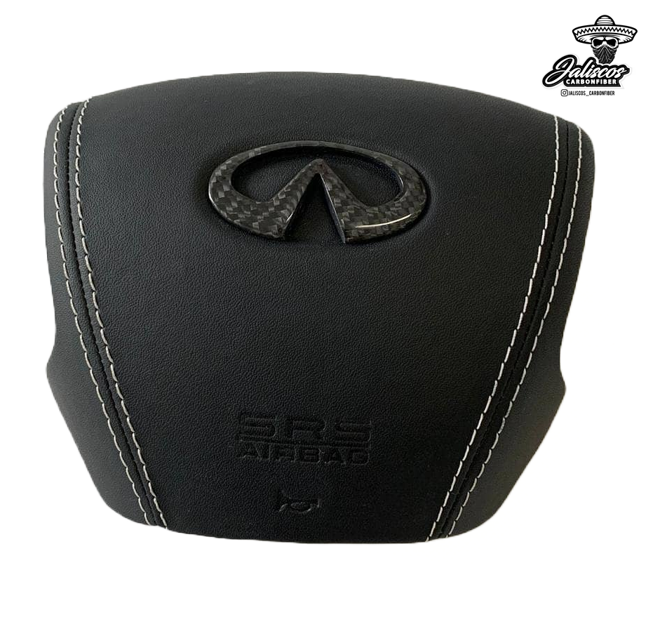 Jalisco's CarbonFiber Custom Airbag Cover for Infiniti Q50 2014-2017: An intricately designed cover featuring white stitching and a high-gloss carbon fiber Infiniti emblem, showcasing premium craftsmanship and elegance. Note: Professional installation recommended."